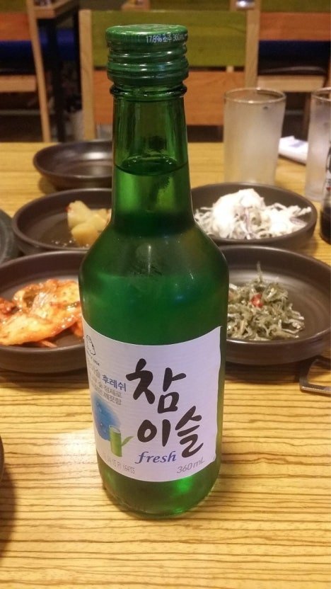 Botella de soju Chamisul en una mesa coreana con banchan