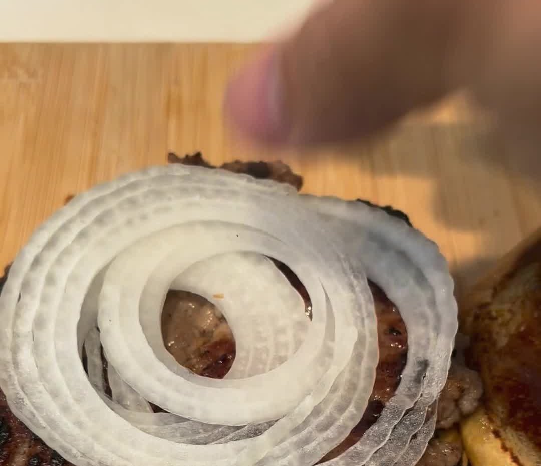 Aros de cebolla cruda sobre la hamburguesa bulgogi