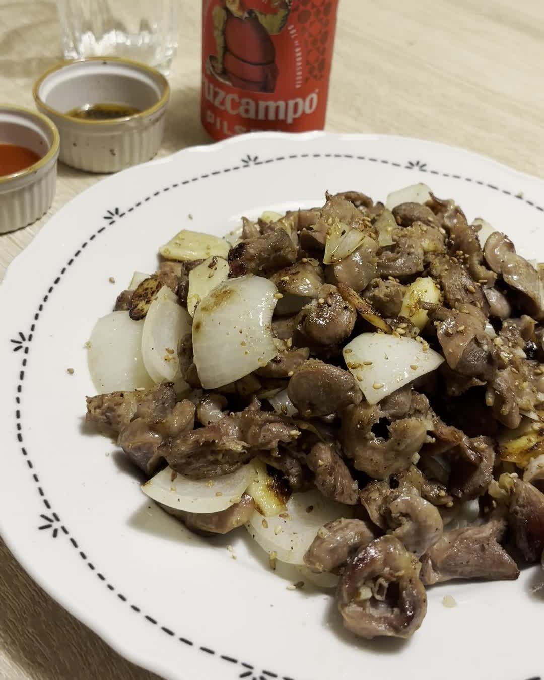 Mollejas de pollo a la coreana con cebolla y ajo, servidas en un plato